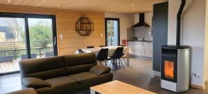 a living room with a couch and a kitchen with a table at Chalet avec jacuzzi privé, 3 chambres in Traubach-le-Haut