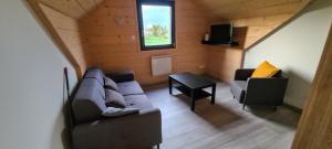 a living room with a couch and a table at Chalet avec jacuzzi privé, 3 chambres in Traubach-le-Haut