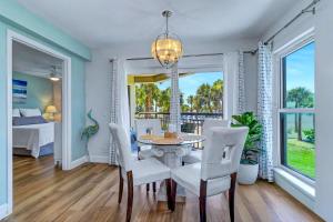 a dining room with a table and chairs and a bedroom at Gulf Strand Resort 207 in St. Pete Beach