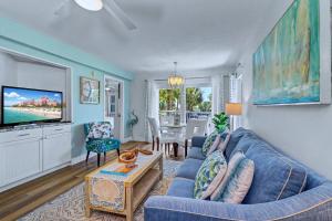 a living room with a blue couch and a tv at Gulf Strand Resort 207 in St. Pete Beach +35 photos