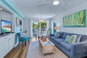 a living room with a blue couch and a table at Gulf Strand Resort 207 in St. Pete Beach