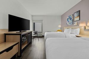 a hotel room with two beds and a flat screen tv at City Express by Marriott Yulee in Yulee