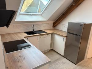 a kitchen with a stainless steel refrigerator and a window at Sur les toits de Beaugency in Beaugency +10 photos