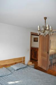 a bedroom with a bed and a chandelier at Chambre d'hôte l'Argentier in Noyarey