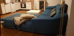 a blue couch sitting in a living room at Ferienhof Uckermark am Oberuckersee in Suckow +12 photos