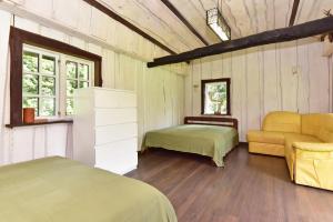 a room with two beds and a couch and windows at 4gilės sodyba Alytaus rajone in Kružiūnai