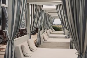 a row of beds with curtains and tables at Finca Hotel Rural Es Turó Spa in Ses Salines