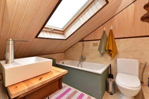 a bathroom with a sink and a toilet and a skylight at 4gilės sodyba Alytaus rajone in Kružiūnai +65 photos