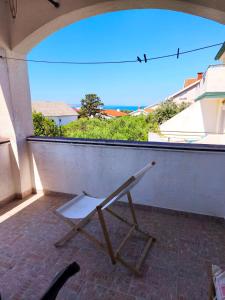a chair sitting on a balcony with a view at Studio Stela 3 in Povljana +5 photos