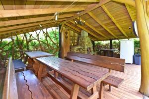 a wooden table and benches on a wooden deck at 4gilės sodyba Alytaus rajone in Kružiūnai