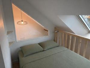 a small room with a bed and a staircase at Sur les toits de Beaugency in Beaugency