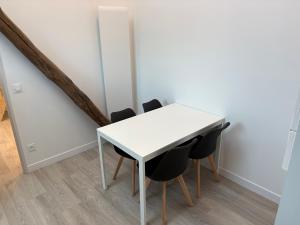 a white table and chairs in a room at Sur les toits de Beaugency in Beaugency