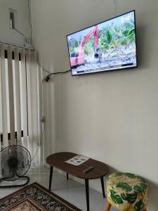 a flat screen tv hanging on a wall at Homestay Berlian T in Alastuwo