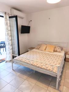 a bed in a bedroom with a tv on the wall at Studio Stela 3 in Povljana