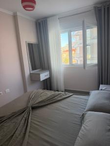 a bedroom with a bed with a television and a window at Shengjin Paradise Apartment in Shëngjin +3 photos
