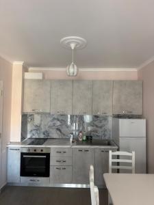 a kitchen with stainless steel appliances and a table at Shengjin Paradise Apartment in Shëngjin