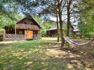 a log cabin with a hammock in front of it at Leśna Arkadia in Dominice