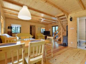 a dining room and living room with a table and chairs at Leśna Arkadia in Dominice