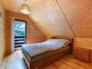 a bedroom with a bed in a wooden cabin at Leśna Arkadia in Dominice