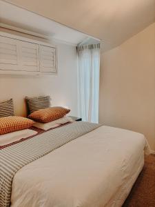 a bedroom with a large white bed with two pillows at Slow Haus Tanunda in Tanunda