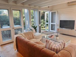 a living room with a couch and a tv at Slow Haus Tanunda in Tanunda