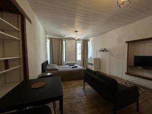 a living room with a bed and a couch and a table at Studios Citadelle in Parthenay
