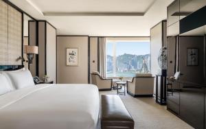 a hotel room with a bed and a large window at The Peninsula Hong Kong in Hong Kong