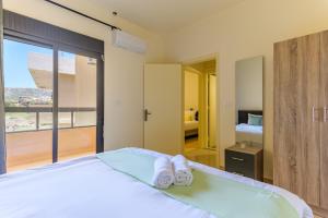 a bedroom with a bed with towels on it at Mauve et Miel 2-BR Apartment In Batroun in Batroûn