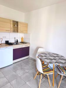a kitchen with a table and chairs in a room at Studio Stela 3 in Povljana