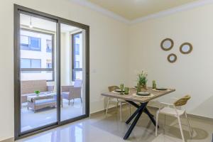 a dining room with a table and a glass door at Mauve et Miel 2-BR Apartment In Batroun in Batroûn
