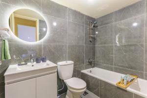 a bathroom with a toilet and a sink and a tub at Mauve et Miel 2-BR Apartment In Batroun in Batroûn +16 photos