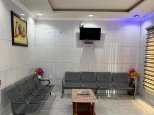 a waiting room with chairs and a flat screen tv at Giyani Shamba Lodge in Giyani