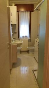 ein Bad mit einem Waschbecken, einem WC und einem Fenster in der Unterkunft Casa Mia in Sottomarina