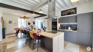 a kitchen with a long island with a long bar at Le Tarare in Guipy