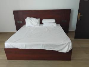 a large bed with white sheets and pillows on it at Monara Blue Beach in Dickwella