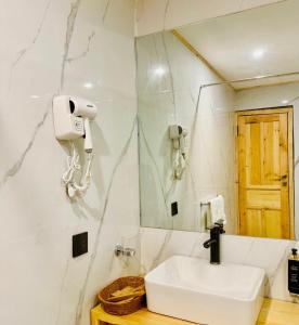 a bathroom with a sink and a phone on the wall at Meechung Resort in Skardu +13 photos
