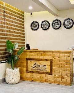 a counter with clocks on the wall and a plant at Meechung Resort in Skardu