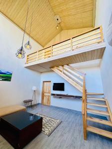 a loft apartment with a staircase and a living room at Meechung Resort in Skardu