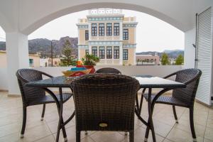 a table and chairs on a balcony with a building at Manto Studios in Palaiochora