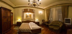 a bedroom with a bed and a couch and a chair at Hotel Staromiejski in Krasnystaw