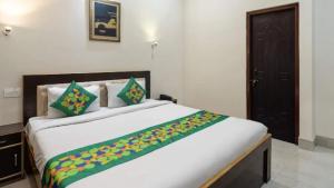 a bedroom with a large white bed with green pillows at Zouk Homes in Rishīkesh