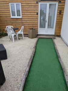 a patio with a green floor in front of a house at Studio bois avec jardinet in Parentis-en-Born