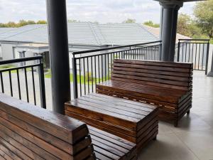two wooden benches sitting on a balcony at Giyani Shamba Lodge in Giyani