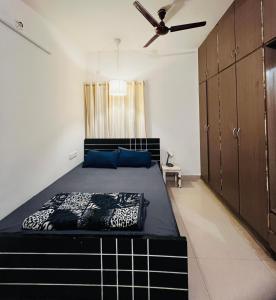 a bedroom with a bed and a ceiling fan at Electrifying Pearl in Bangalore