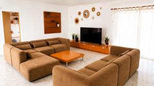 a living room with two couches and a flat screen tv at Villa Savanna Spacious villa with private pool near the beach in Cala en Blanes