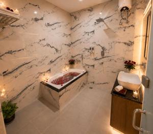 a bathroom with a white marble wall at Hotel Manglam Inn Near CCS International Airport in Lucknow