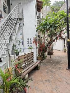 a wooden bench sitting next to a building with plants at Nangyang lodge in Malacca