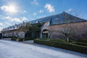 a large brick building with the sun behind it at La MASSERIA in Thuin