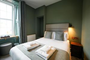 a bedroom with a bed with two towels on it at The Whisky Vaults in Oban