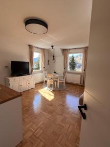 a living room with a table and a television at Oaza Narave Apartment, Peaceful Retreat near Bled & Vintgar in Spodnje Gorje
